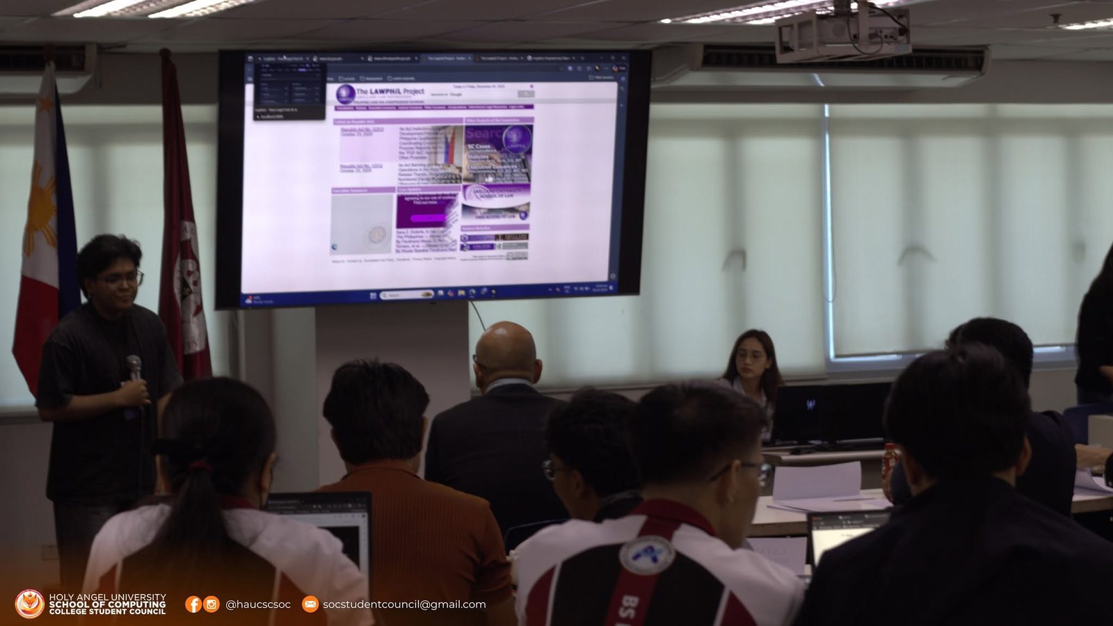 A student pitching to the room with a legal database open on the screen behind him