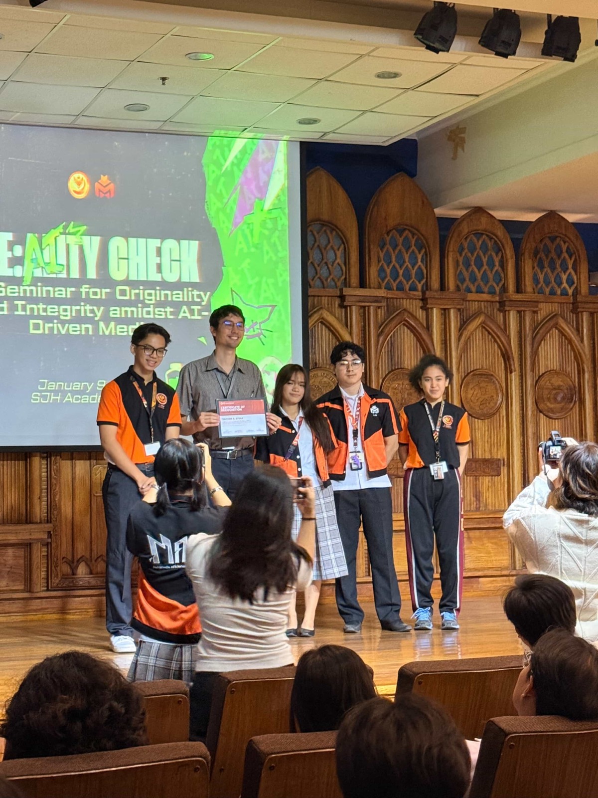 The organizers handing me the certificate of recognition on stage, four of them in their org shirts