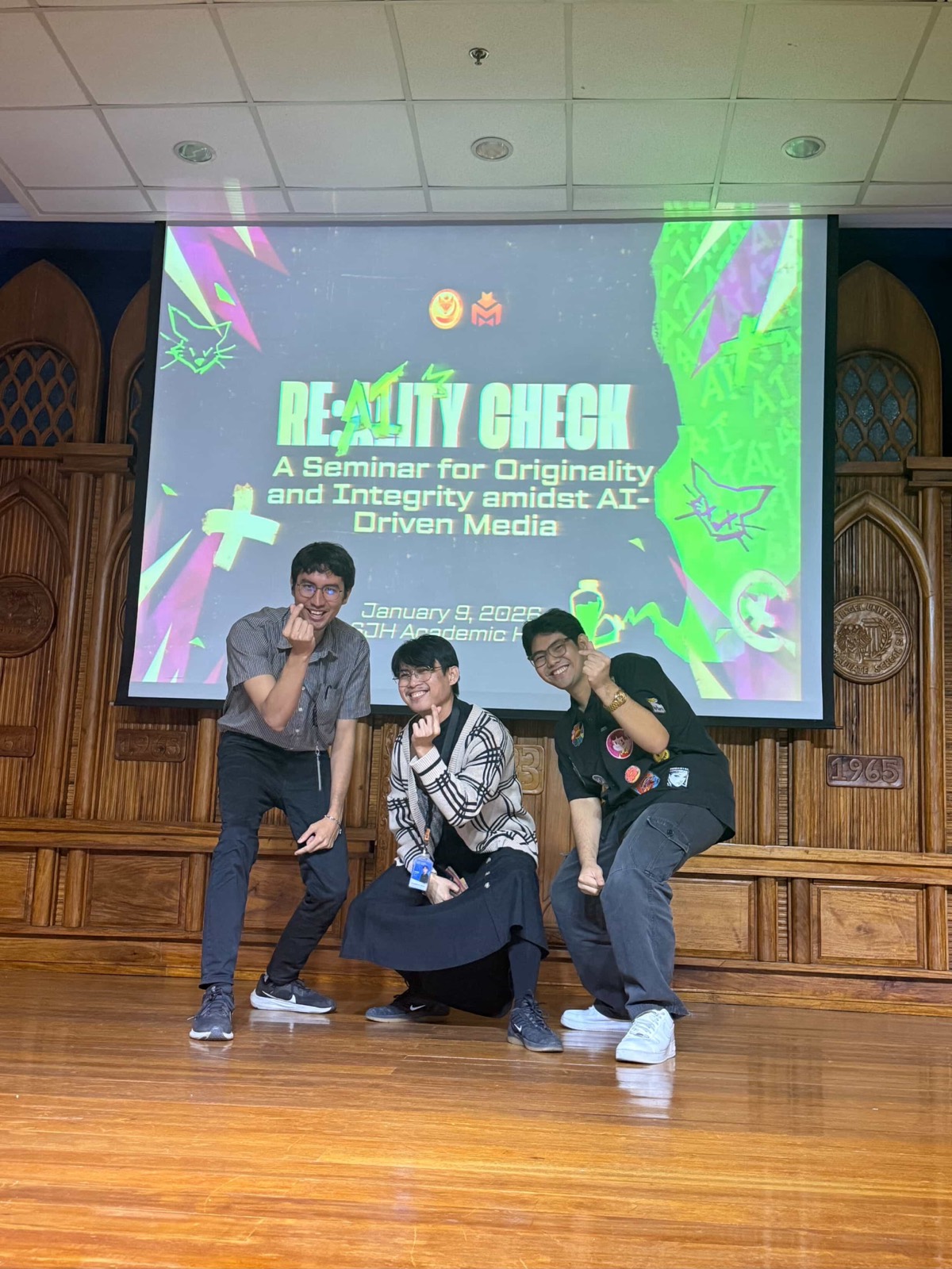 The three of us doing finger hearts in front of the Re: AI-lity Check title slide after the session