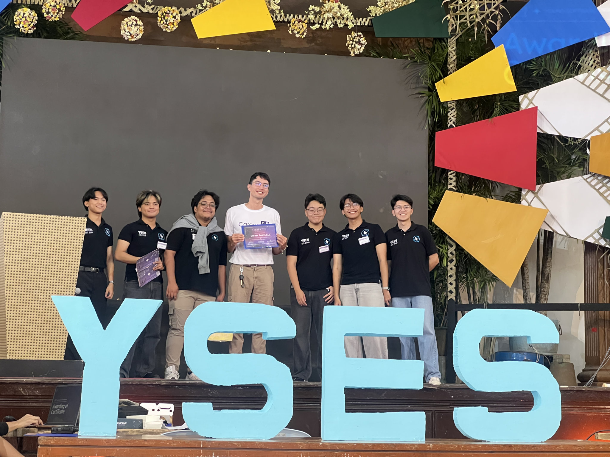 The YSES officers handing me the certificate on stage afterwards, six of them in their org shirts