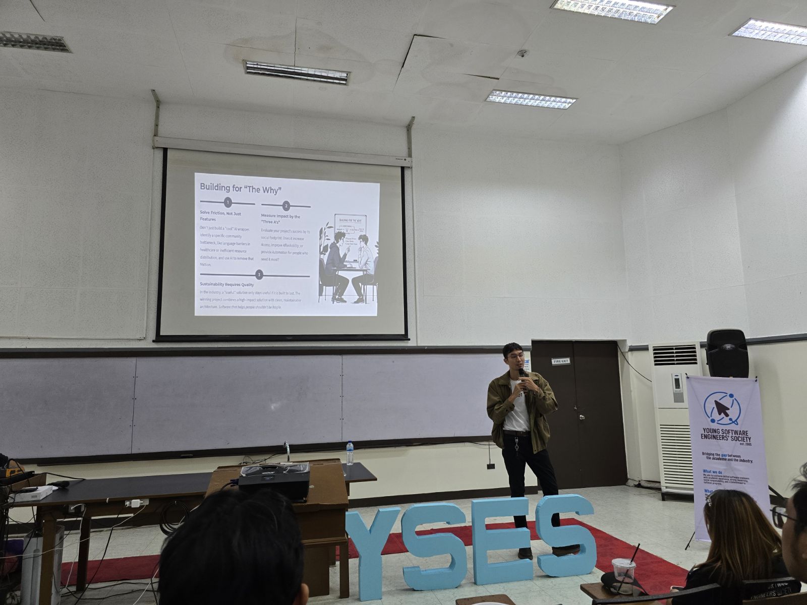 The Building for The Why slide up on the projector, three numbered points, while I talk to the room from beside the YSES letters